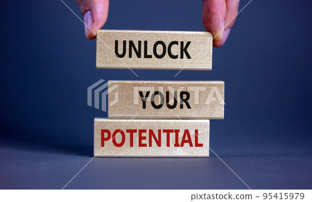 Male hand placing a block with word 'unlock' on top of a blocks tower with words 'unlock your potential'. Beautiful grey background. Copy space. Business concept. Male hand placing a block with word 'unlock' on top of a blocks tower with words 'unlock your potential'. Beautiful grey background. Copy space. Business concept. 95415979