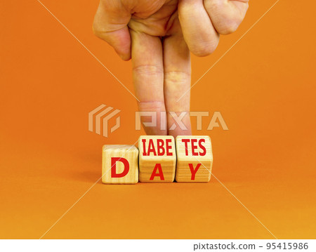 Diabetes day symbol. Concept words Diabetes day on wooden cubes. Doctor hand. Beautiful orange table orange background. Medical and Diabetes day concept. Copy space. Diabetes day symbol. Concept words Diabetes day on wooden cubes. Doctor hand. Beautiful orange table orange background. Medical and Diabetes day concept. Copy space. 95415986