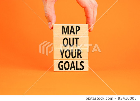 Support and map out your goals symbol. Concept words Map out your goals on wooden blocks on beautiful orange table orange background. Businessman hand. Business, support and map out your goals concept Support and map out your goals symbol. Concept words Map out your goals on wooden blocks on beautiful orange table orange background. Businessman hand. Business, support and map out your goals concept 95416003