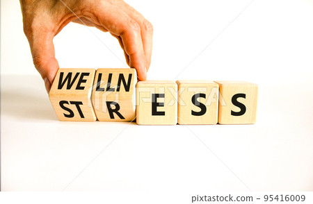 Stress or wellness symbol. Concept words Stress or Wellness on wooden cubes. Businessman hand. Beautiful white table white background. Business stress or wellness concept. Copy space. Stress or wellness symbol. Concept words Stress or Wellness on wooden cubes. Businessman hand. Beautiful white table white background. Business stress or wellness concept. Copy space. 95416009