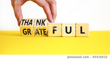 Thankful and grateful symbol. Concept words Thankful and Grateful on wooden cubes. Businessman hand. Beautiful yellow table white background. Business thankful and grateful concept. Copy space. Thankful and grateful symbol. Concept words Thankful and Grateful on wooden cubes. Businessman hand. Beautiful yellow table white background. Business thankful and grateful concept. Copy space. 95416010