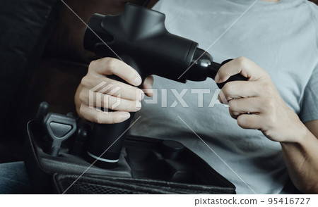 man about to use a massage gun, banner format 95416727