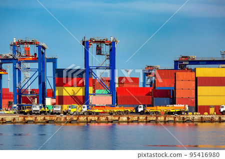 long trucks in container depot in import and export area at port near sea port on warehouse colorful marine containers with gantry container cranes for loading freight to vehicle, nobody. 95416980