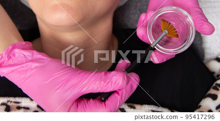 Young white woman getting acid organic retinol peel face skin with the brush in a beauty clinic. 95417296