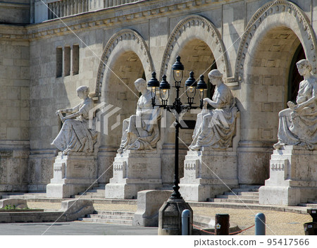 Three arched entrances with statues and an ornamental street lamp Three arched entrances with statues and an ornamental street lamp 95417566