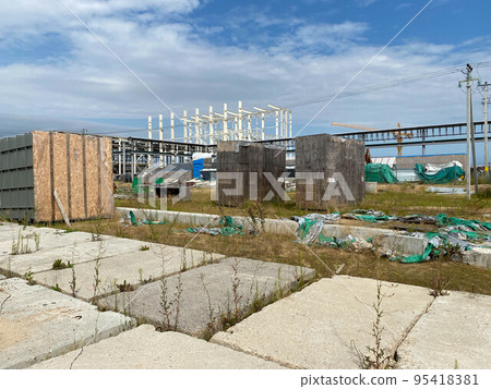 A large outdoor warehouse at a construction site, a warehouse for industrial equipment and materials in boxes at an open-air storage site 95418381