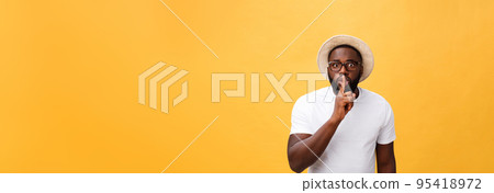 Closeup portrait of handsome bald man placing finger on lips as if to say, isolated on yellow background with copy space Closeup portrait of handsome bald man placing finger on lips as if to say, isolated on yellow background with copy space 95418972