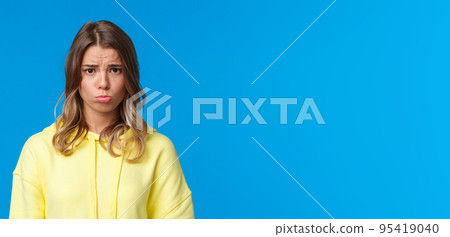 Close-up portrait cute gloomy and upset sulky blond girl with short haircut, sobbing and pouting frowning distressed, offended being rejected or let down, standing blue background Close-up portrait cute gloomy and upset sulky blond girl with short haircut, sobbing and pouting frowning distressed, offended being rejected or let down, standing blue background 95419040