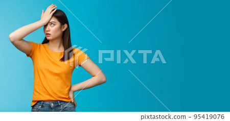 Annoyed arrogant asian girl punch forehead make facepalm sign, roll eyelids irritated pissed, cannot stand lame talks look disappointed ingorant, unwilling to listen, stand blue background Annoyed arrogant asian girl punch forehead make facepalm sign, roll eyelids irritated pissed, cannot stand lame talks look disappointed ingorant, unwilling to listen, stand blue background 95419076