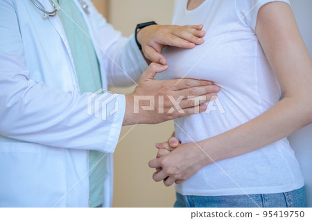 Experienced healthcare worker performing the breast examination 95419750