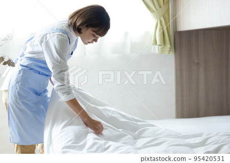 Cute woman making a bed Cute woman making a bed 95420531