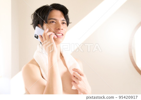 Young man talking on the phone in the washroom Men's beauty image Young man talking on the phone in the washroom Men's beauty image 95420917