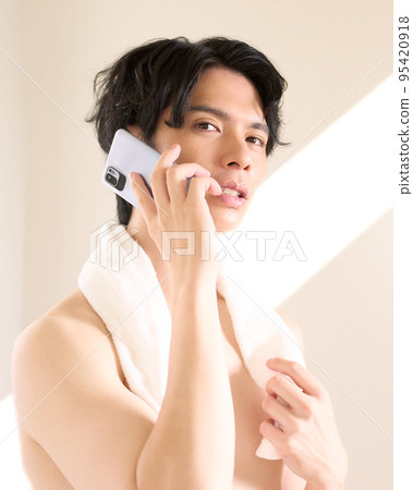 Young man talking on the phone in the washroom Men's beauty image Young man talking on the phone in the washroom Men's beauty image 95420918