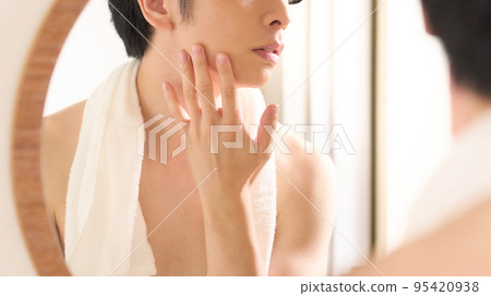 Hands of a man checking his skin while looking in the mirror Men's beauty image 95420938
