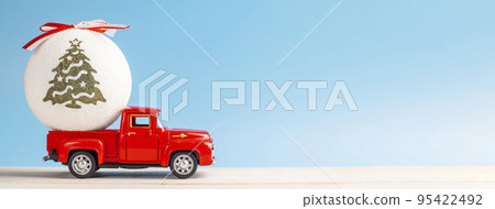 Christmas red retro car with a Christmas ball on a blue background Christmas red retro car with a Christmas ball on a blue background 95422492