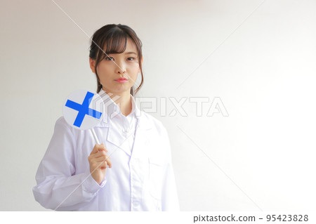 A white coat woman with a negative expression holding a plate with a cross mark 1 A white coat woman with a negative expression holding a plate with a cross mark 1 95423828