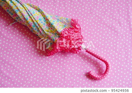 A frilly umbrella with a small floral pattern used by an elementary school girl A frilly umbrella with a small floral pattern used by an elementary school girl 95424936