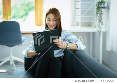 internet learning, online shopping, selling, meeting, information searching, young Asian woman using tablet mobile to work at home internet learning, online shopping, selling, meeting, information searching, young Asian woman using tablet mobile to work at home 95424990