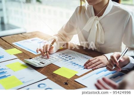 financial, Brainstorming, Data Analysis, Planning, Marketing and Accounting, Economist using calculator to calculate investment documents with partners on profit taking to compete with other companies 95424996