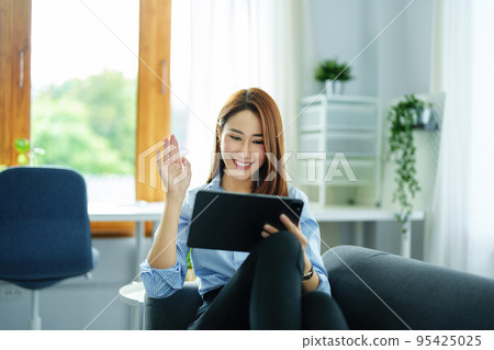 internet learning, online shopping, selling, meeting, information searching, young Asian woman using tablet mobile to work at home internet learning, online shopping, selling, meeting, information searching, young Asian woman using tablet mobile to work at home 95425025