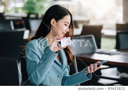 Online Shopping and Internet Payments, Beautiful Asian women are using their mobile phones and credit cards to shop online or conduct errands in the digital world Online Shopping and Internet Payments, Beautiful Asian women are using their mobile phones and credit cards to shop online or conduct errands in the digital world 95425813