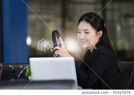 Concept of taking a break from work, an accountant or a female company employee or a business owner is using headphones to listen to music to relieve stress and fatigue from work 95425876