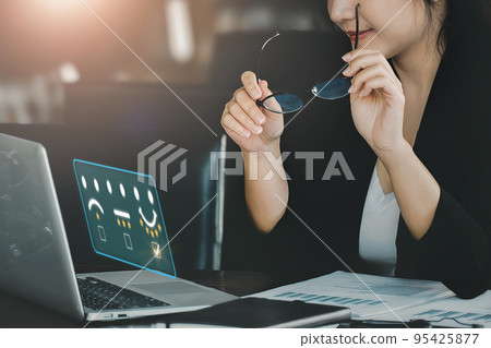 Quality and Satisfaction Rating Concept, Assessment, smiling businesswoman using laptop computer to answer surveys and assess 5-star satisfaction 95425877