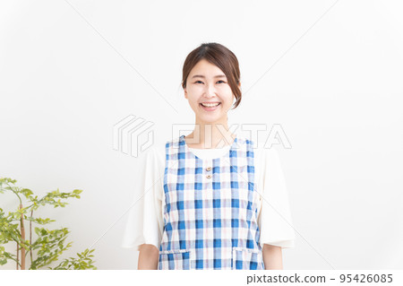一位穿著圍裙微笑的幼兒園老師 95426085