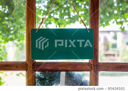 Blank sign on the wooden door in front of the cafe. Copy space background 95426501