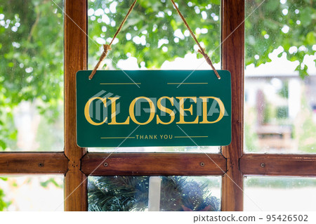 The sign is closed on the wooden door in front of the cafe. The sign is closed on the wooden door in front of the cafe. 95426502