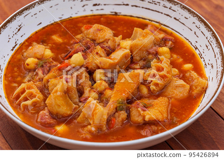 Madrid style tripe on rustic plate on a wooden table. Callos a la Madrilena - typical spanish dish Madrid style tripe on rustic plate on a wooden table. Callos a la Madrilena - typical spanish dish 95426894
