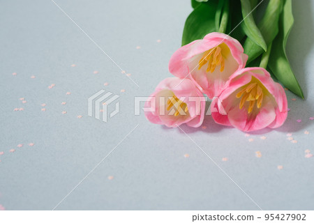 A bouquet of pink tulips on a soft blue background with pink confetti. Valentine's day, March 8, birthday, mother's day and Easter. Copy space A bouquet of pink tulips on a soft blue background with pink confetti. Valentine's day, March 8, birthday, mother's day and Easter. Copy space 95427902