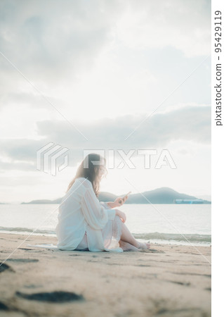 一個女人在沙灘上打電話的照片 一個女人在沙灘上打電話的照片 95429119