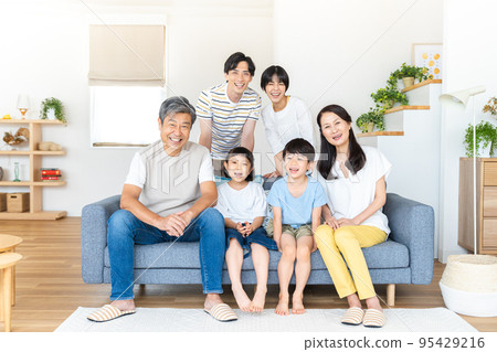 A three-generation family relaxing in the living room A three-generation family relaxing in the living room 95429216