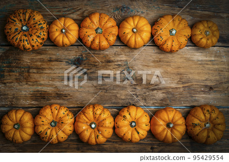 Pumpkins on a wooden rustic background. Yellow autumn harvest pumpkins on the festive table. Fall holidays, halloween, thanksgiving day, food concept. 95429554