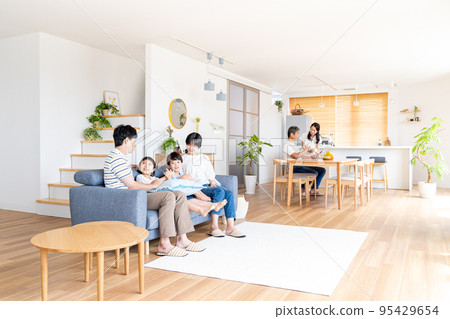 A three-generation family relaxing in the living room 95429654