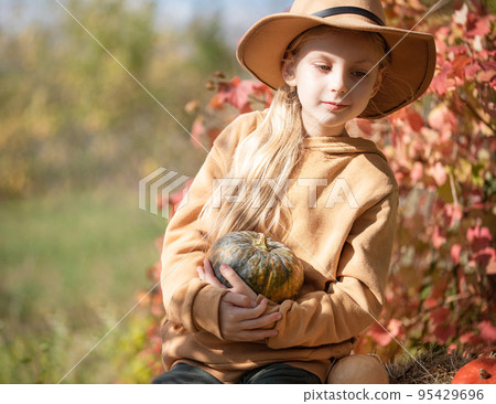 Girl in the hay with pumpkins Girl in the hay with pumpkins 95429696
