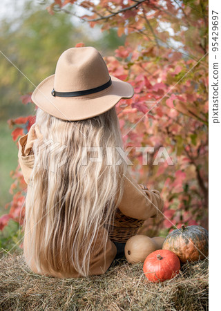 Girl in the hay with pumpkins Girl in the hay with pumpkins 95429697