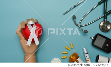 Blue ribbon, glucose meter, lancet pen, stethoscope and syringe on blue background. World diabetes day and health care concept 95429854