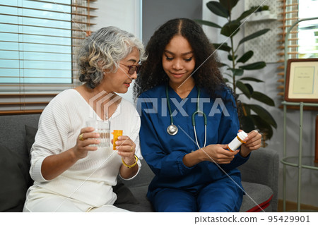 Practitioner nurse explaining medicine dosage to senior patient. Elderly healthcare and Home health care service concept Practitioner nurse explaining medicine dosage to senior patient. Elderly healthcare and Home health care service concept 95429901