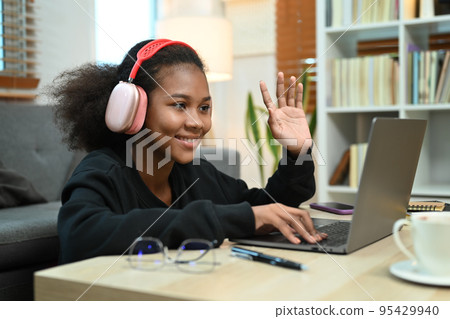 Smiling teenage girl watching learning online in virtual classroom on laptop laptop. E-learning education concept 95429940