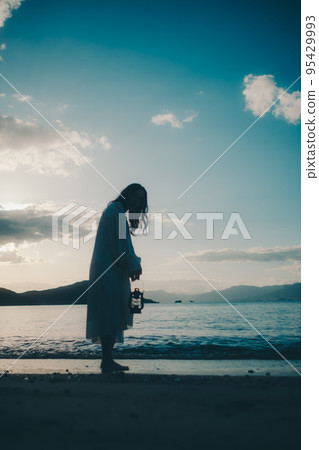 Photo of a woman standing by the beach Photo of a woman standing by the beach 95429993