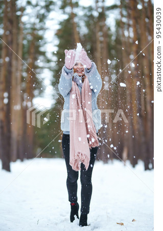 Cute young woman is playing with snow in the forest. Winter lifestyle happiness emotions nature. Cute young woman is playing with snow in the forest. Winter lifestyle happiness emotions nature. 95430039