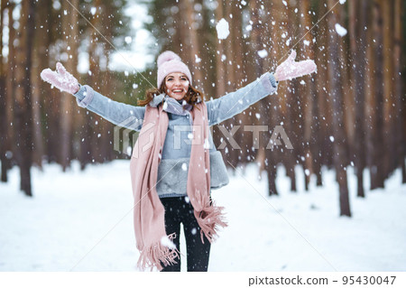Cute young woman is playing with snow in the forest. Winter lifestyle happiness emotions nature. Cute young woman is playing with snow in the forest. Winter lifestyle happiness emotions nature. 95430047