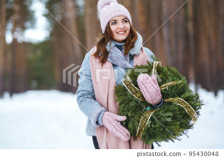 Young woman holding traditional green christmas wreath. Celebration winter event. New Year party, Christmas. Young woman holding traditional green christmas wreath. Celebration winter event. New Year party, Christmas. 95430048
