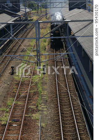 蒸汽機車噴著煙進入鳥棲站月台的景象 95430170