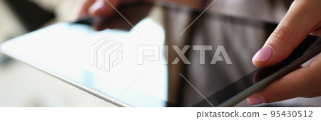 Female using digital tablet device for work or entertainment, black gadget screen 95430512