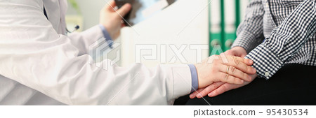 Qualified male doctor with lungs x ray scan calm female patient on appointment 95430534