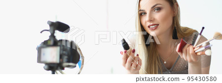 Charming beautiful young woman present beauty products for facial makeup on camera 95430580