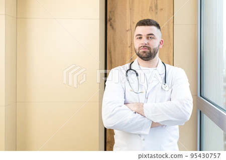 Portrait of young doctor man with medical instruments, smiling, looking at camera Portrait of young doctor man with medical instruments, smiling, looking at camera 95430757